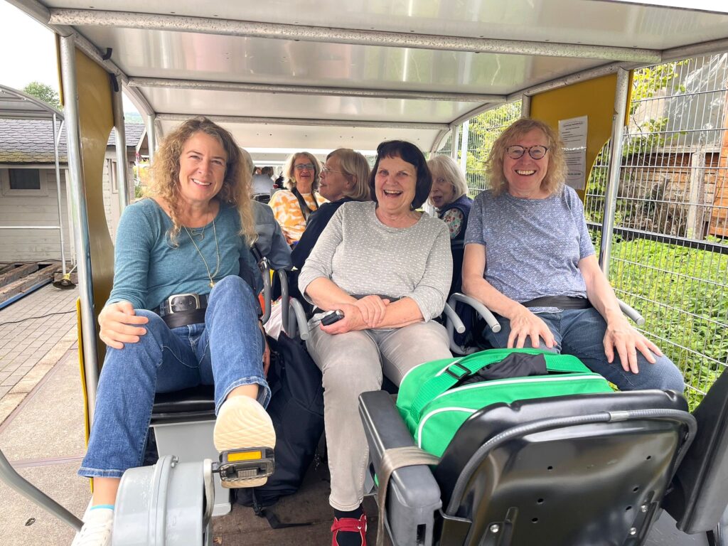 a group of women sitting in a trolley - Lachclub Frankfurt in der Draisine 31. Juni 2025